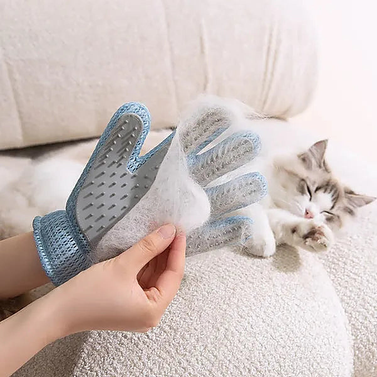 Grooming glove peeling a sheet of loose cat fur off, cat resting on a couch